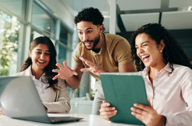 People working on a desk looking at computer